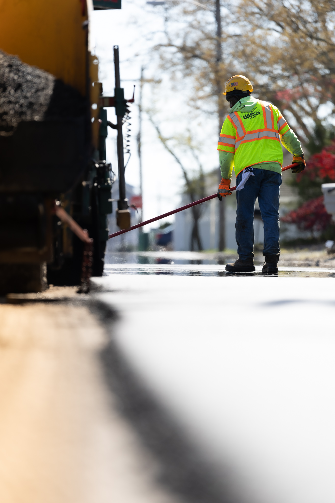 American Asphalt employee sealing cracks on road