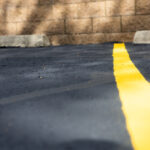 Line striping equipment painting crisp, yellow marking on asphalt parking surface