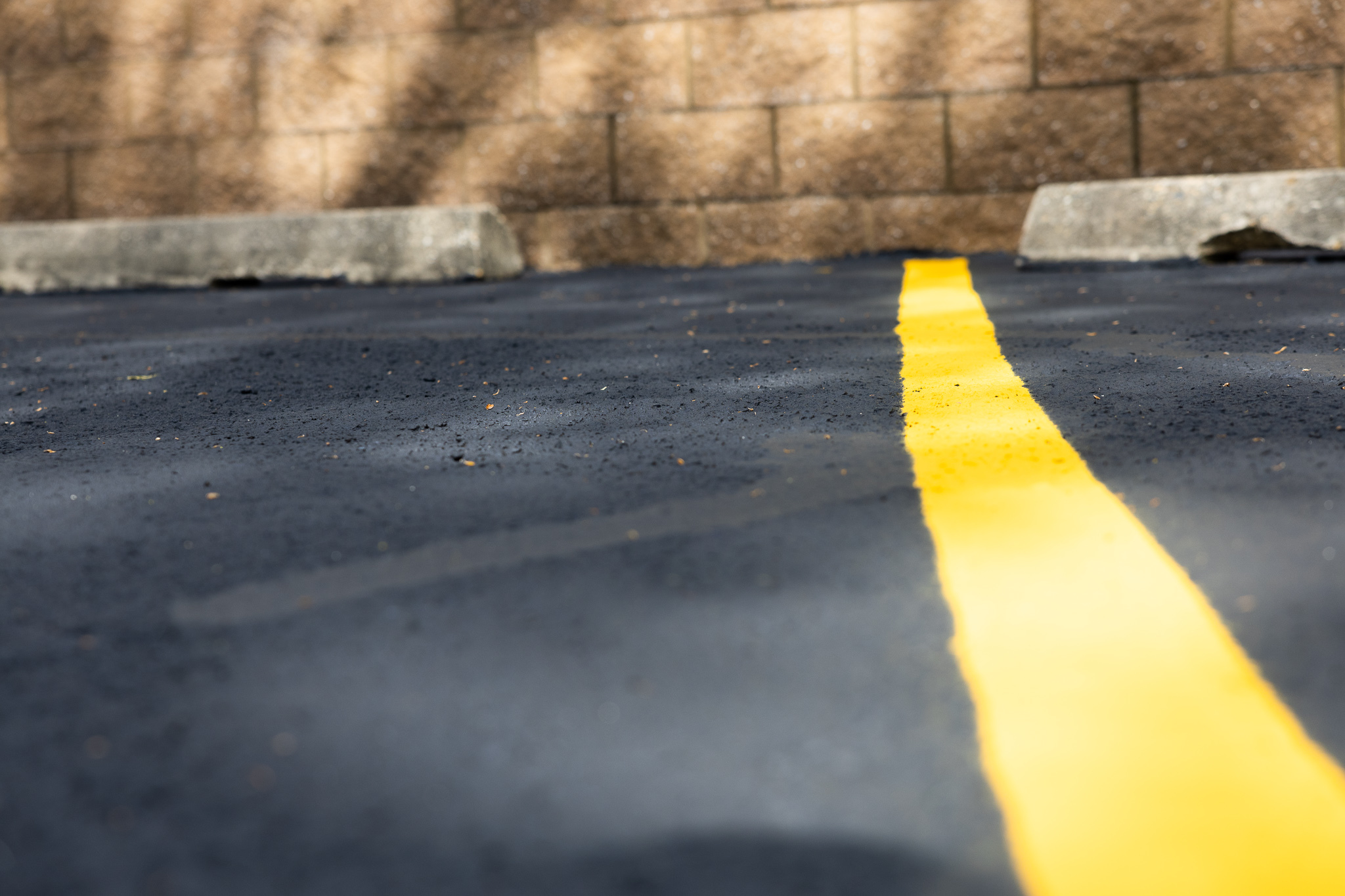 Line striping equipment painting crisp, yellow marking on asphalt parking surface