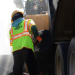 Worker laying asphalt on road