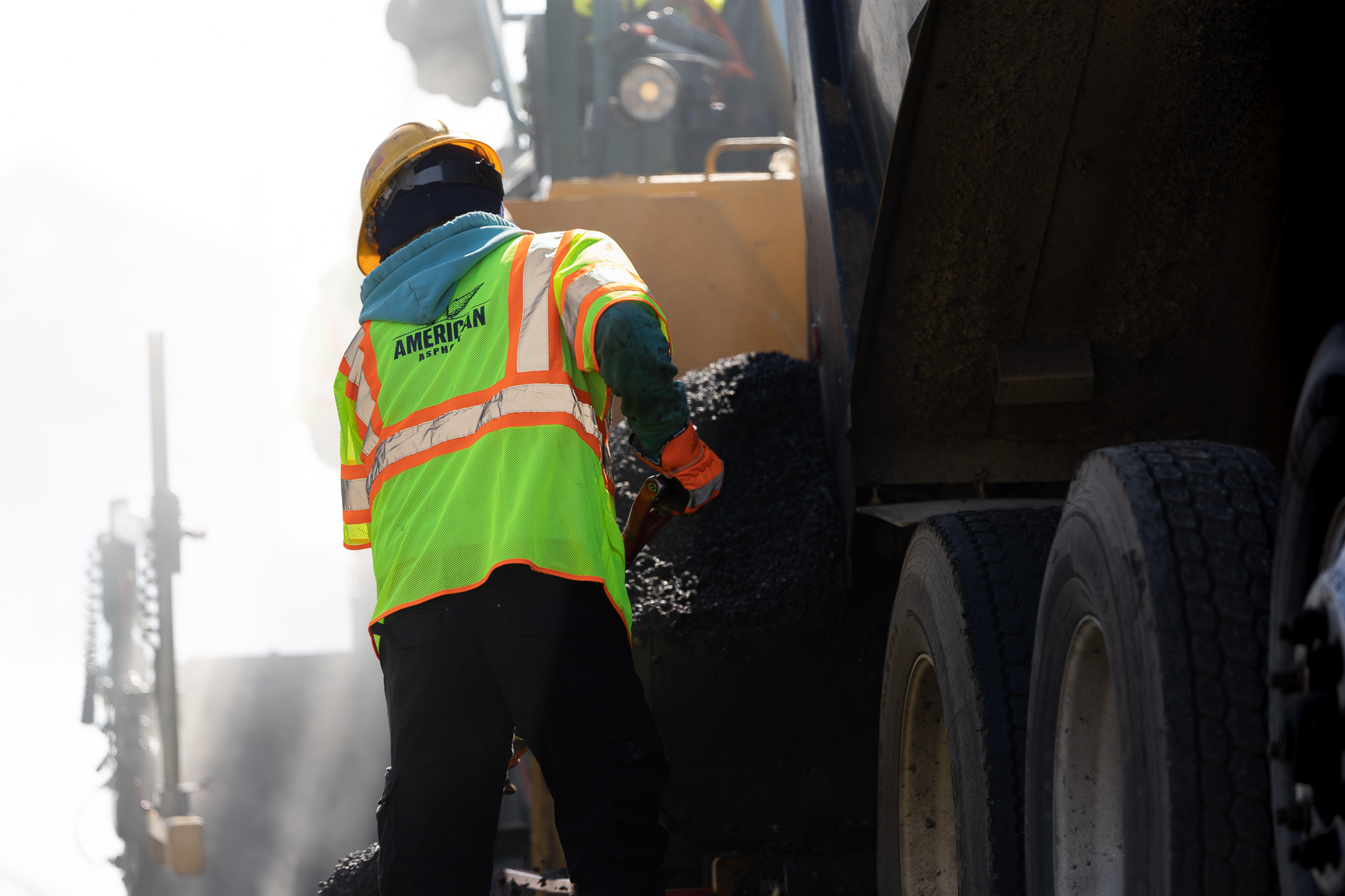 Worker laying asphalt on road