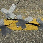 Crack in asphalt with duct tape over it