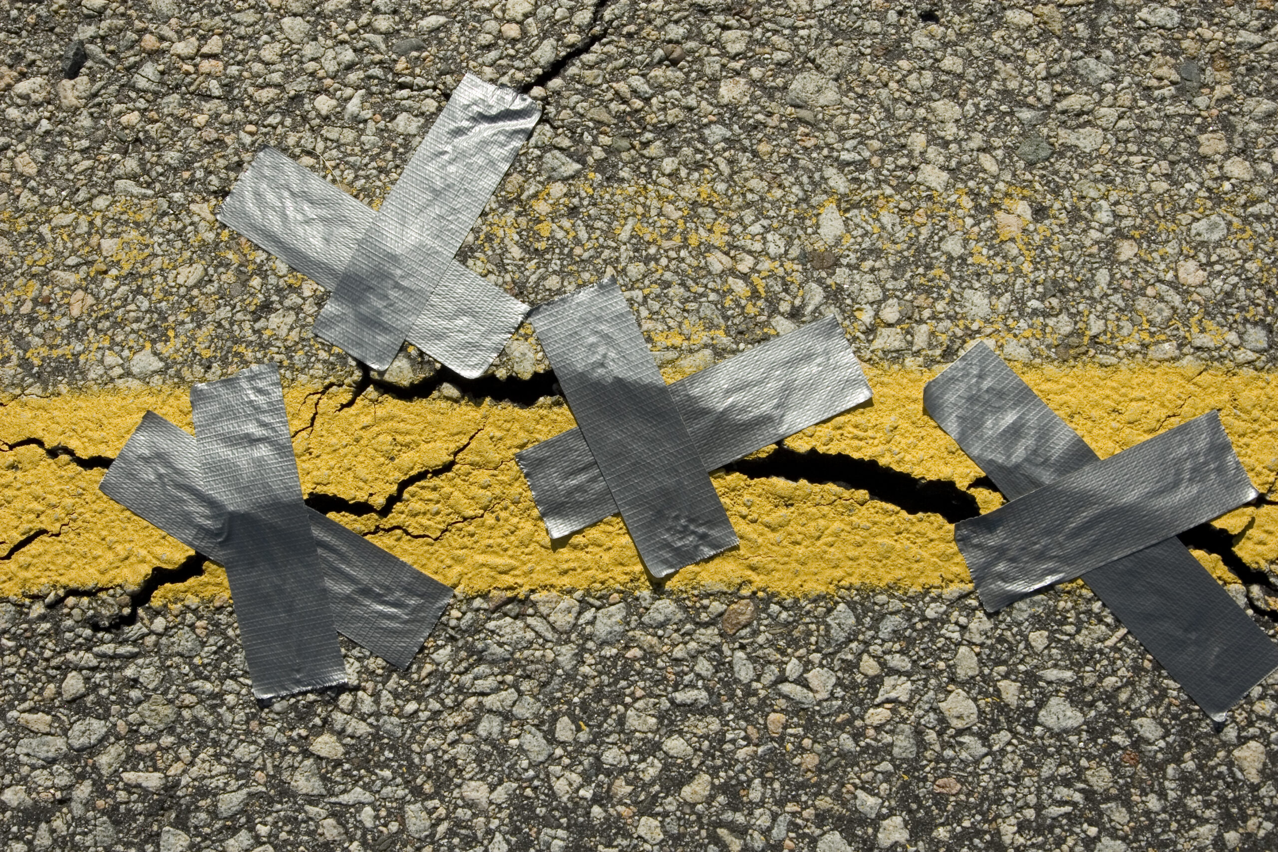 Crack in asphalt with duct tape over it